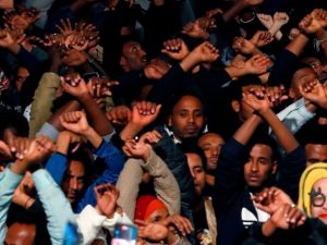 African migrants and Israelis demonstrate with their arms crossed against the Israeli government’s policy to forcibly deport African refugees and asylum seekers to Rwanda and Uganda.